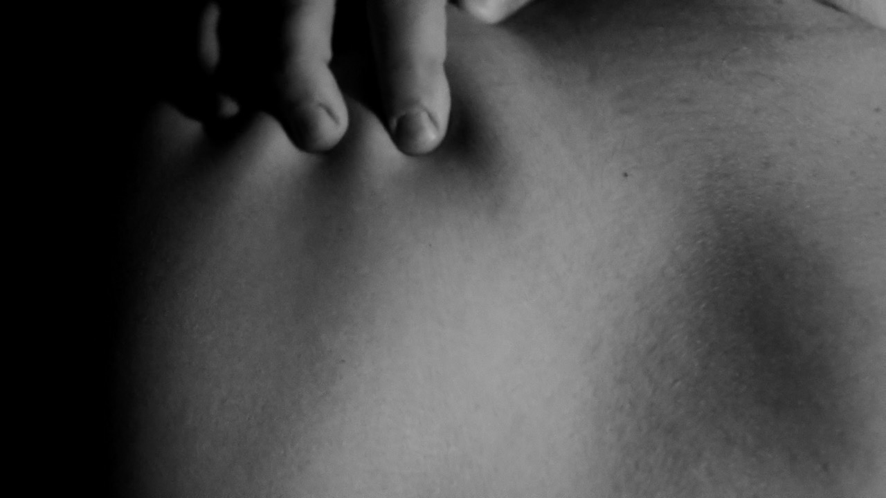 screenshot de ma vidéo de packshot d'une gameboy. On y voit le dos d'un homme nu avec la main d'un autre homme qui lui serre l'épaule sensuellement.